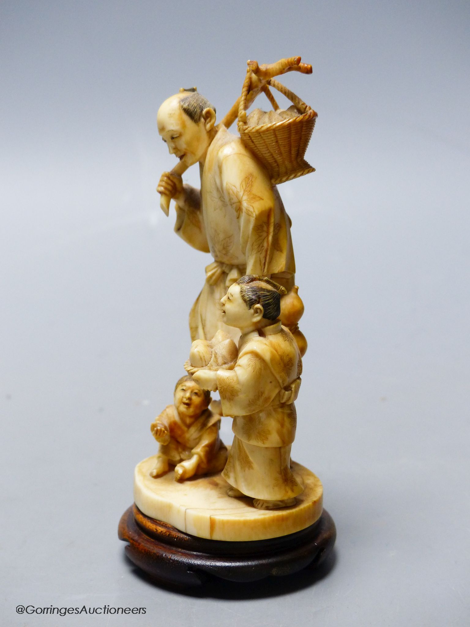 A Japanese ivory okimono of a peach seller